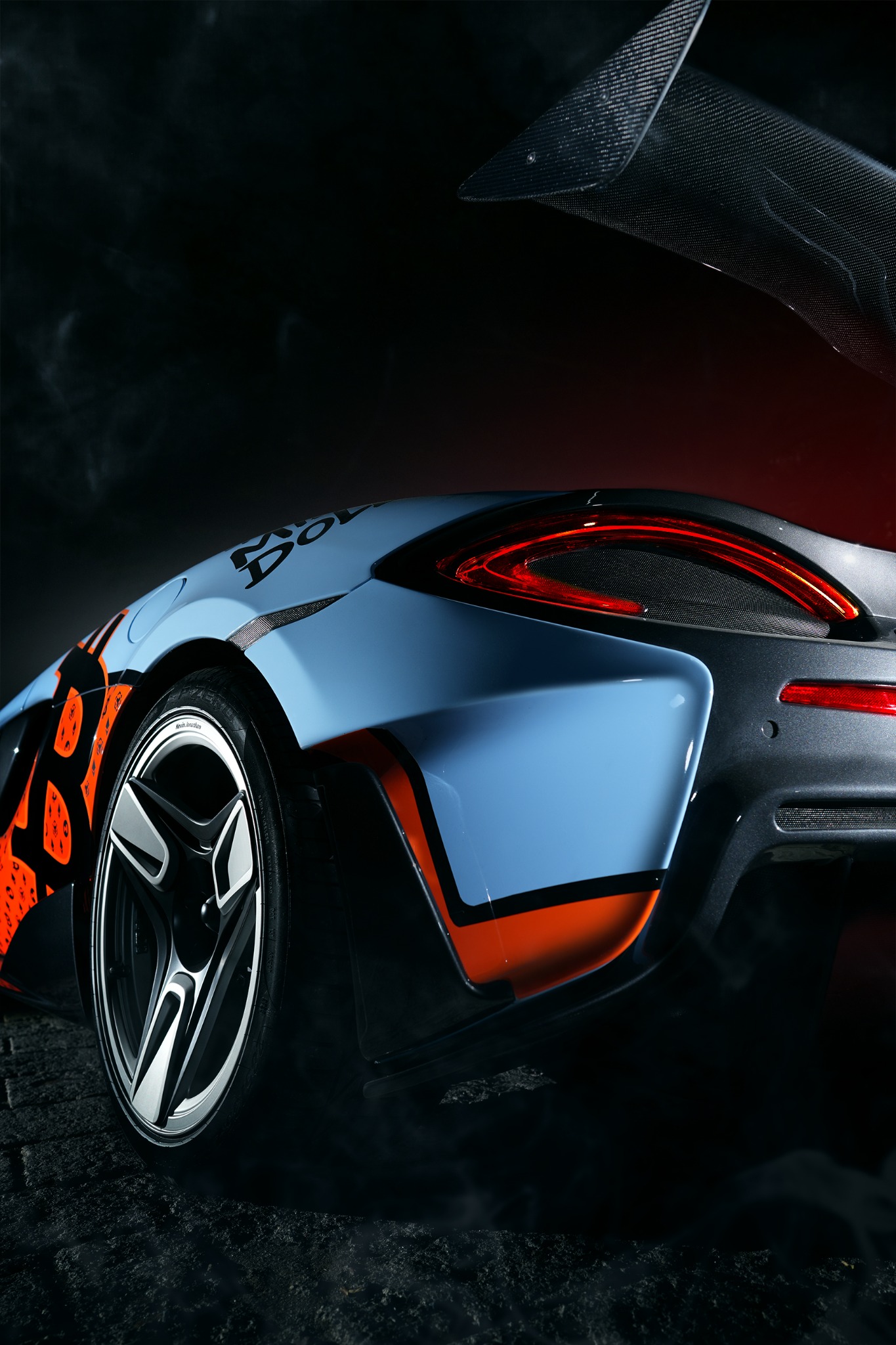 Blue and orange McLaren in a cinematic night setting
